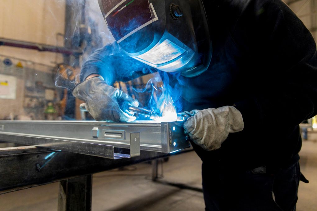 Welder running a TIG bead, arc light on steel